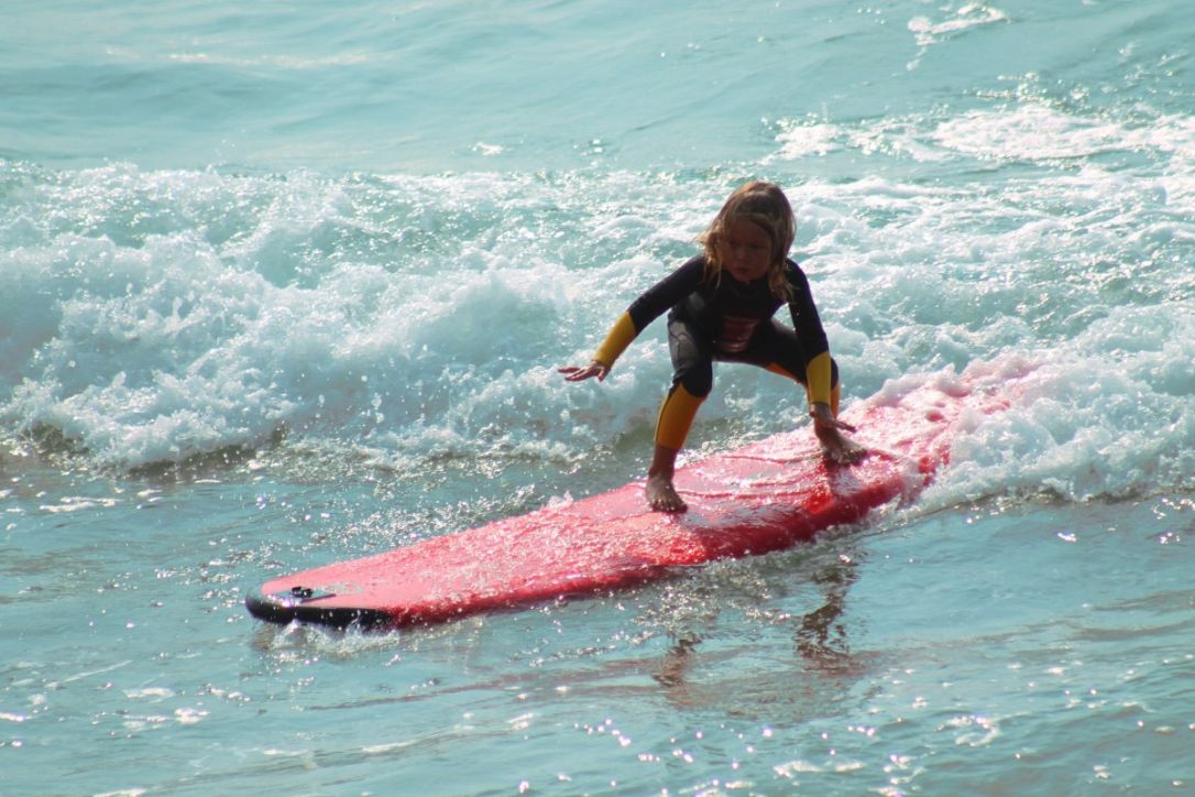 Dziecko w piance neoprenowej na desce surfingowej